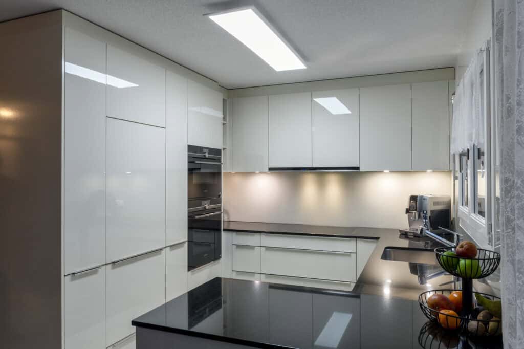 Moderne weiße Einbauküche mit viel Stauraum und eleganten Oberflächen, ideal für stilvolles Kochen u.