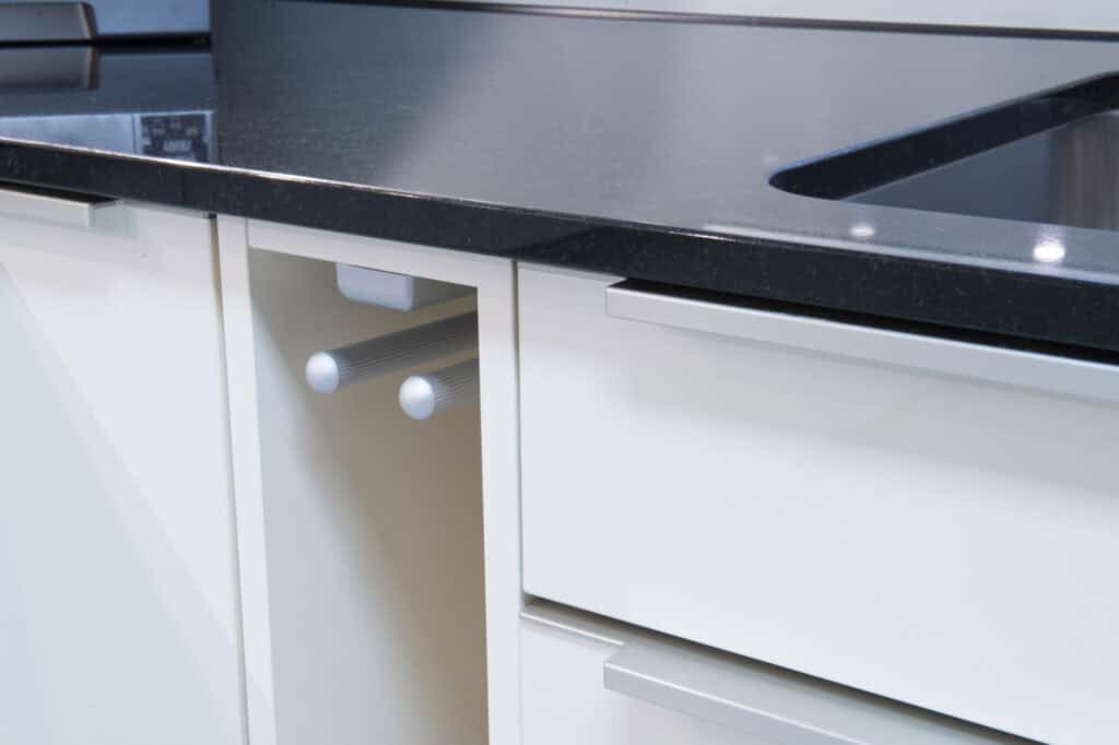 Hochwertige weiße Küchenmöbel mit schwarzer Arbeitsplatte, modernem Design.