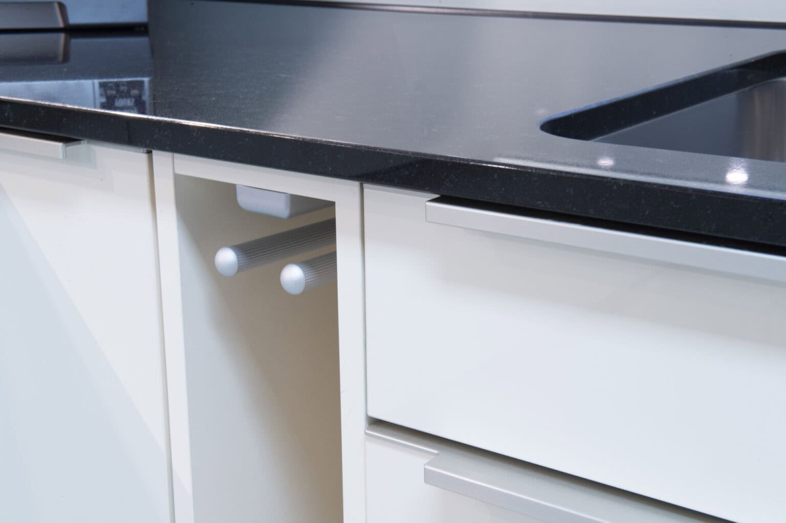 Hochwertige weiße Küchenmöbel mit schwarzer Arbeitsplatte, modernem Design.