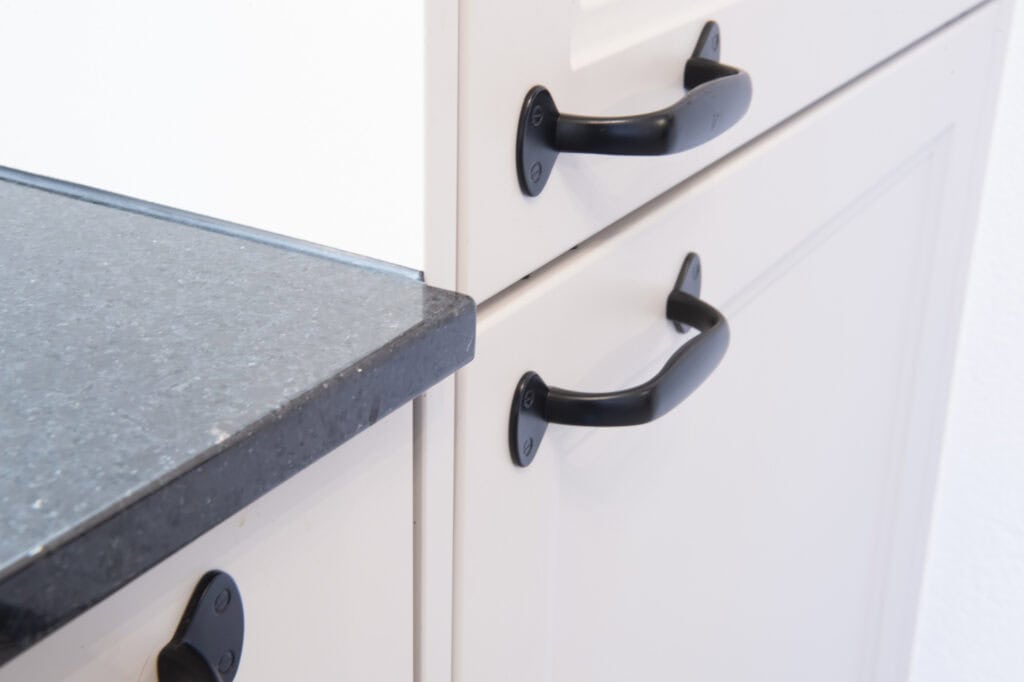 Schwarze Küchen-Griffe an weißen Schubladen in Mori Küchen.