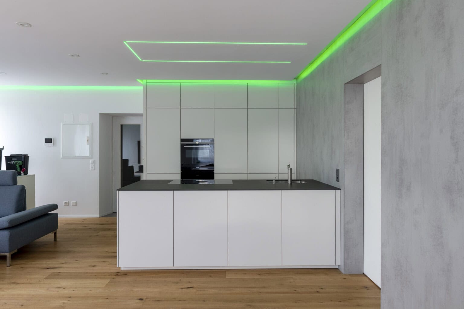 Küche mit grüner LED-Deckenbeleuchtung und weißem Küchenschrank
