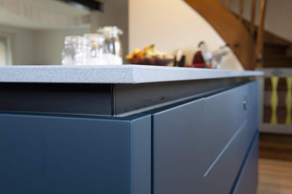 Blaue Küchenschränke mit hellem Arbeitsplatten in moderner Küche.