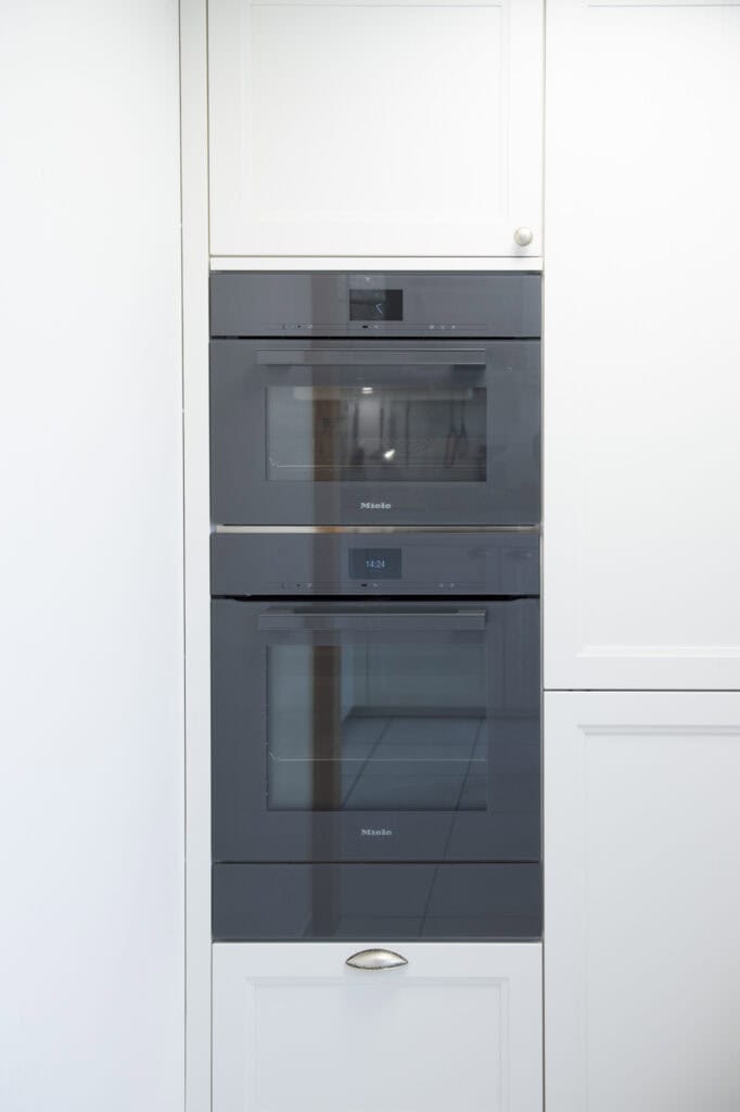 Schwarze Einbaugeräte in weißer Küchenwand