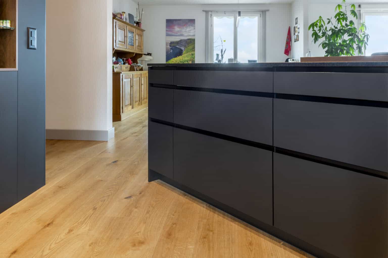 Kücheninsel mit dunklem Schrank und Holzboden