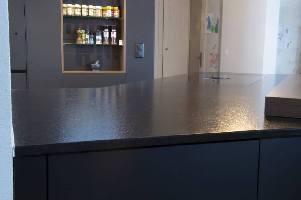 Moderne Küchentheke mit dunklem Oberflächenmaterial, ideal für Küchen und Essbereiche.