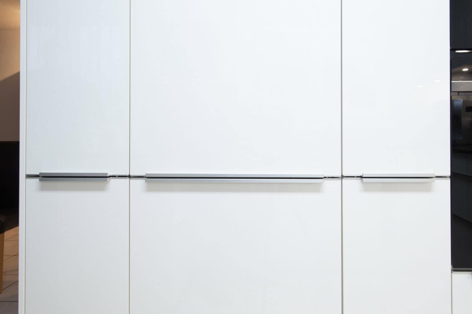 Weiße Küchenmöbel mit glatten Oberflächen und eleganten Griffen, ideal für moderne Küchen.