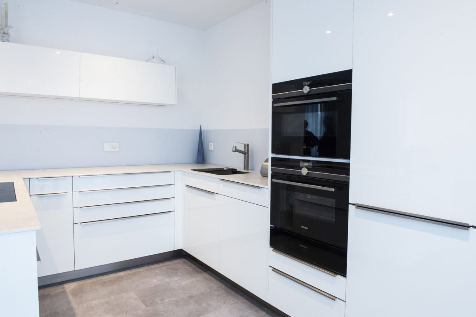 Weisse Küchenzeile mit schwarzen Einbaubacköfen