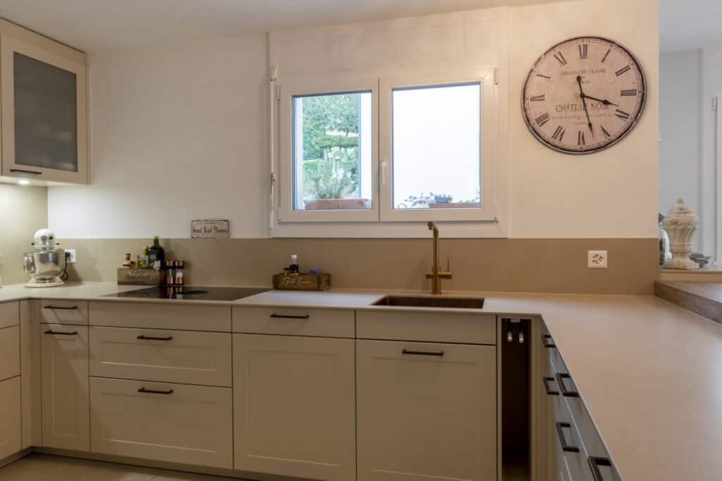 Helle Küche mit großem Fenster und Uhr